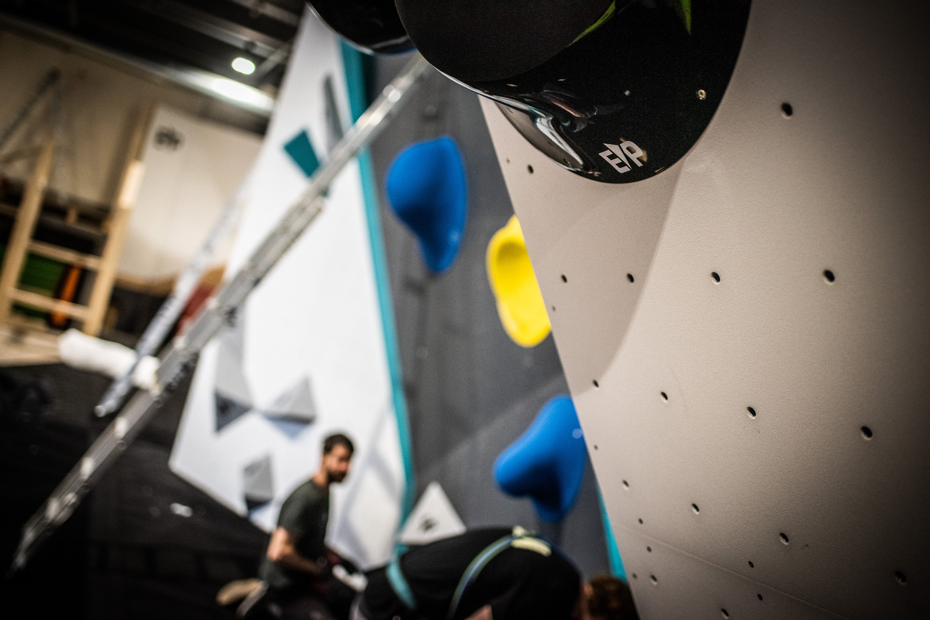 Climbing wall with colorful holds in an indoor climbing gym.